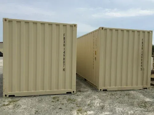 Two tan 20-foot storage containers standing end to end on a gravel lot